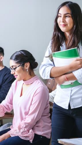 Femme portant un manuel scolaire blanc et vert